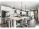 Open kitchen with white cabinets, stainless appliances, and eat-in island at 7218 Antiquity Dr, Carmel, IN 46033