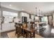Open-concept kitchen and dining area featuring a dark wood table, island with bar stools, and modern appliances at 7218 Antiquity Dr, Carmel, IN 46033