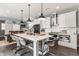 Well-appointed kitchen with a large center island, stainless steel appliances, pendant lighting, and sleek white cabinets at 7218 Antiquity Dr, Carmel, IN 46033