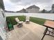 Relaxing backyard featuring a concrete patio with seating, a lush green lawn, and a white fence at 728 Jefferson Park Dr, Pittsboro, IN 46167