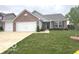 Well-maintained brick home with a two-car garage and a lush green lawn at 728 Jefferson Park Dr, Pittsboro, IN 46167