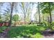 View of the lush, well-manicured backyard featuring mature trees and a privacy fence at 7626 Timber Springs S Dr, Fishers, IN 46038