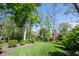 The backyard features a large, well-maintained lawn and mature trees at 7626 Timber Springs S Dr, Fishers, IN 46038