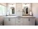A modern bathroom features white cabinets with granite countertops, and large framed mirrors over each sink at 7626 Timber Springs S Dr, Fishers, IN 46038