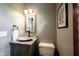 Half bath with granite countertop, vessel sink, and decorative mirror at 7626 Timber Springs S Dr, Fishers, IN 46038