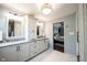 A bright bathroom boasts marble floors, and sinks, and a view to the main bedroom at 7626 Timber Springs S Dr, Fishers, IN 46038