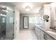A bright bathroom boasts marble floors, and sinks with gray countertops, and a glass enclosed shower at 7626 Timber Springs S Dr, Fishers, IN 46038
