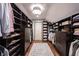 A huge walk-in closet with custom dark wood shelving and drawers provides ample storage space at 7626 Timber Springs S Dr, Fishers, IN 46038