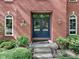 Close-up of brick home's entryway showcasing double doors with glass panels and decorative sconces at 7626 Timber Springs S Dr, Fishers, IN 46038