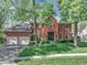 Charming brick home with a well-maintained lawn, mature trees, and a convenient two-car garage at 7626 Timber Springs S Dr, Fishers, IN 46038