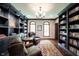 Well-appointed home office with hardwood floors, custom shelving, and plenty of natural light at 7626 Timber Springs S Dr, Fishers, IN 46038