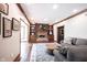 Living room with a brick fireplace, built-in shelving, hardwood floors, and a comfortable gray sofa at 7626 Timber Springs S Dr, Fishers, IN 46038