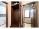 A mudroom with dark wood locker storage including hooks and open cubbies with a half-bathroom visible at 7626 Timber Springs S Dr, Fishers, IN 46038