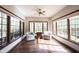 Bright sunroom with hardwood floors, ceiling fan, and large windows offering abundant natural light at 7626 Timber Springs S Dr, Fishers, IN 46038