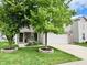 Charming home featuring a two-car garage, well-maintained lawn, and beautiful mature trees at 7804 Amadeus Dr, Indianapolis, IN 46239