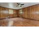 Bedroom with wood paneled walls, hardwood floors, ceiling fan, and two windows, provides a classic and comfortable retreat at 8140 Valley Estates Dr, Indianapolis, IN 46227