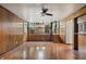 Open living room with wood paneling, stairs, and a glimpse into the adjacent kitchen at 8140 Valley Estates Dr, Indianapolis, IN 46227