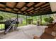 Covered patio with exposed beams, wicker furniture, and outdoor cooking area perfect for entertaining at 8140 Valley Estates Dr, Indianapolis, IN 46227