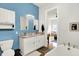 This bathroom features a double vanity, blue accent wall, and access to the living room at 829 Olive St, Indianapolis, IN 46203