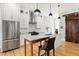 Elegant kitchen with stainless steel appliances, sleek white cabinets, and a beautiful rustic barn door accent at 829 Olive St, Indianapolis, IN 46203