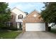Charming two-story brick home with a two-car garage, a well-maintained lawn, and mature trees at 8551 Walden Trace Dr, Indianapolis, IN 46278