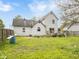 Sprawling backyard shows house, grass, deck, landscaping, and fencing under a blue sky at 907 S Ohio St, Sheridan, IN 46069
