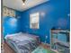 This is a cozy bedroom with blue walls, a dinosaur poster, and a comfortable bed at 907 S Ohio St, Sheridan, IN 46069