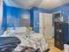 Bedroom with a blue accent wall, carpeted floor, file cabinet, and access to the laundry area at 907 S Ohio St, Sheridan, IN 46069