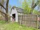 Garage with partially open doors, visible stored items, and fence around the property at 907 S Ohio St, Sheridan, IN 46069