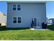 Rear exterior of home with a sliding glass door leading to a patio and a green lawn at 9074 Larson Dr, Pendleton, IN 46064