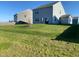 Large backyard with green grass, featuring a tree and partially covered patio area at 9074 Larson Dr, Pendleton, IN 46064