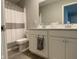 Bathroom featuring double sinks, white cabinets, and shower with gray striped curtain at 9074 Larson Dr, Pendleton, IN 46064