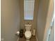 Powder room with a modern toilet, paper holder, and window with blinds at 9074 Larson Dr, Pendleton, IN 46064