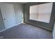 An empty bedroom features neutral-toned walls, carpet, and a window with blinds at 9074 Larson Dr, Pendleton, IN 46064