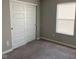 An empty bedroom features neutral-toned walls, carpet, and a window with blinds at 9074 Larson Dr, Pendleton, IN 46064