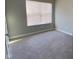 An empty bedroom features neutral-toned walls, carpet, and a window with blinds at 9074 Larson Dr, Pendleton, IN 46064
