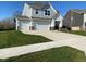 Inviting two-story home featuring a three-car garage, appealing landscaping, and sidewalk at 9074 Larson Dr, Pendleton, IN 46064
