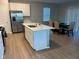 Modern kitchen with stainless steel appliances, a quartz countertop island, and wood floors at 9074 Larson Dr, Pendleton, IN 46064