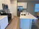 Bright kitchen featuring stainless steel appliances, white cabinetry, an island and laminate floors at 9074 Larson Dr, Pendleton, IN 46064