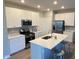 Bright kitchen featuring stainless steel appliances, white cabinetry, an island and laminate floors at 9074 Larson Dr, Pendleton, IN 46064