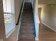 Carpeted staircase featuring a stained handrail with natural light from the window at 9074 Larson Dr, Pendleton, IN 46064