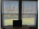 Sunlit view from windows of the landscaped yard with a flat screen TV on a desk at 9074 Larson Dr, Pendleton, IN 46064