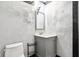 Bathroom featuring modern sink with a mirror, toilet, and stylish wall accents, providing a functional and aesthetically pleasing space at 9510 N Cooney Rd, Mooresville, IN 46158