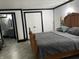 Cozy bedroom featuring a wooden bed frame, ensuite bathroom access, and neutral-toned flooring at 9510 N Cooney Rd, Mooresville, IN 46158