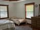 Bedroom with hardwood floors, two beds, light walls, and dresser with mirror at 9510 N Cooney Rd, Mooresville, IN 46158