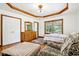 Charming bedroom with tray ceilings, hardwood floors, a dresser with mirror, and a comfortable seating area at 9510 N Cooney Rd, Mooresville, IN 46158