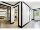 Bright hallway with black trim featuring multiple doorways and a view to the backyard, offering versatile space at 9510 N Cooney Rd, Mooresville, IN 46158