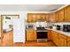 Kitchen with wooden cabinetry, white appliances, and stainless steel oven and microwave at 9510 N Cooney Rd, Mooresville, IN 46158