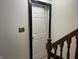 A stairwell is shown with white walls and a closed white door with a black frame in a stairway entrance at 9510 N Cooney Rd, Mooresville, IN 46158