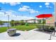 Outdoor patio features a modern firepit, outdoor dining, string lights, red umbrella and lake views at 9557 W Lantern Ln, Pendleton, IN 46064